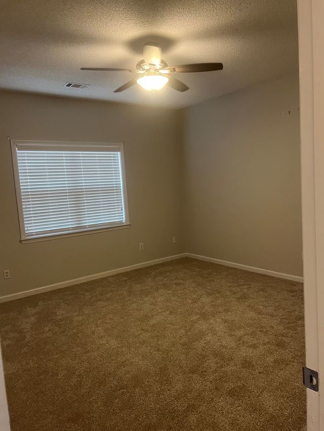 carpeted empty room featuring a textured ceiling and ceiling fan