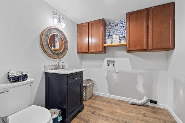 111 Southlake Dr, Eatonton, GA 31024 - clothes washing area with laundry area, wood finished floors, a sink, hookup for a washing machine, and baseboards