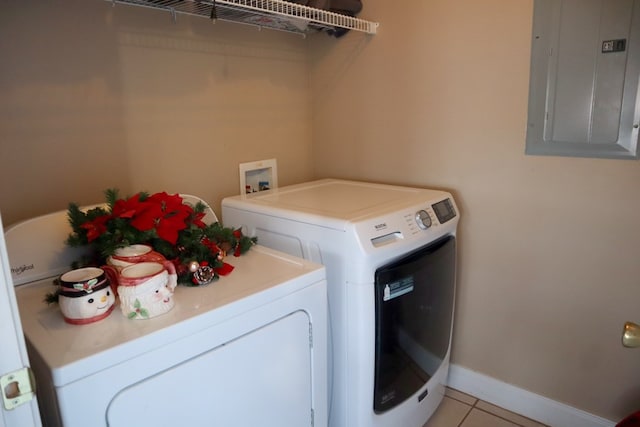 washroom featuring light tile patterned flooring, washing machine and clothes dryer, and electric panel