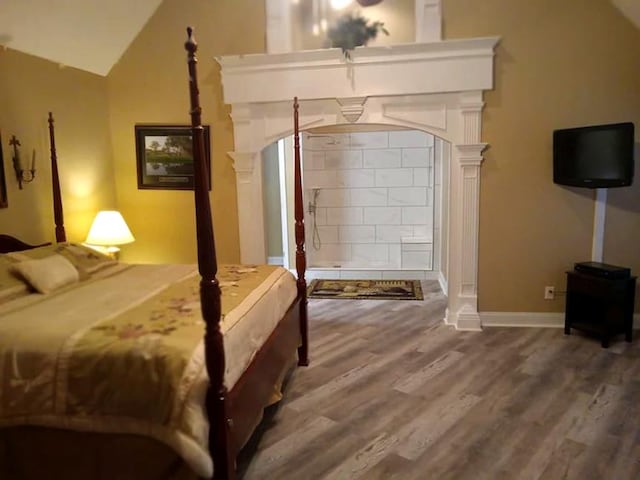 bedroom with lofted ceiling and wood-type flooring