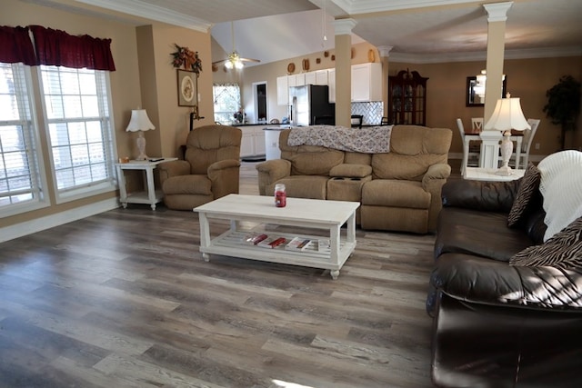 living room featuring ornate columns, crown molding, hardwood / wood-style flooring, and a wealth of natural light