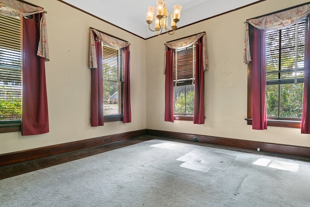 carpeted empty room with a wealth of natural light and a chandelier