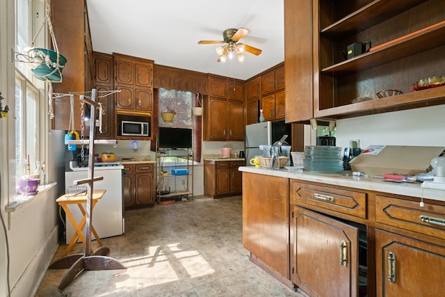 kitchen with separate washer and dryer, ceiling fan, plenty of natural light, and white electric stove