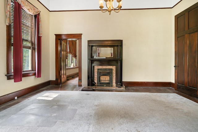 unfurnished living room with a stone fireplace, dark colored carpet, and a notable chandelier