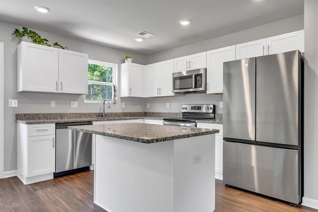 kitchen featuring white cabinetry, a kitchen island, dark wood-type flooring, and appliances with stainless steel finishes