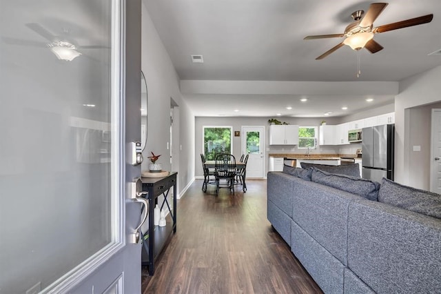 living room with dark hardwood / wood-style floors, ceiling fan, and sink