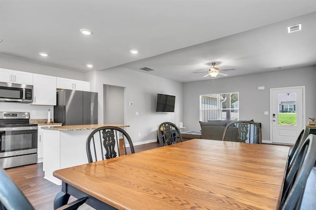 dining space featuring ceiling fan and dark hardwood / wood-style flooring