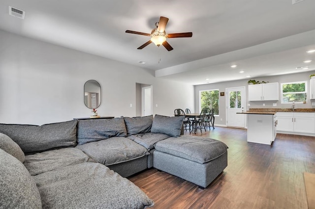 living room featuring ceiling fan, dark wood-type flooring, and sink