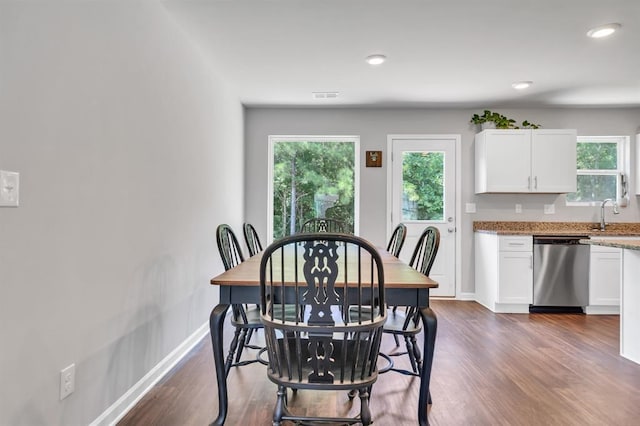 dining room with dark hardwood / wood-style floors and sink