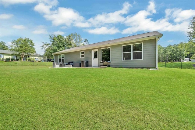 rear view of property featuring a yard and a patio area