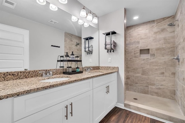 bathroom with vanity, wood-type flooring, and tiled shower