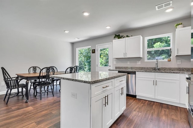 kitchen with white cabinets, sink, stone countertops, a kitchen island, and stainless steel appliances