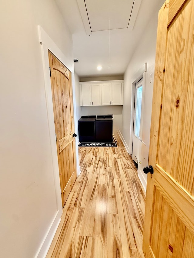 interior space featuring light wood finished floors, attic access, and baseboards