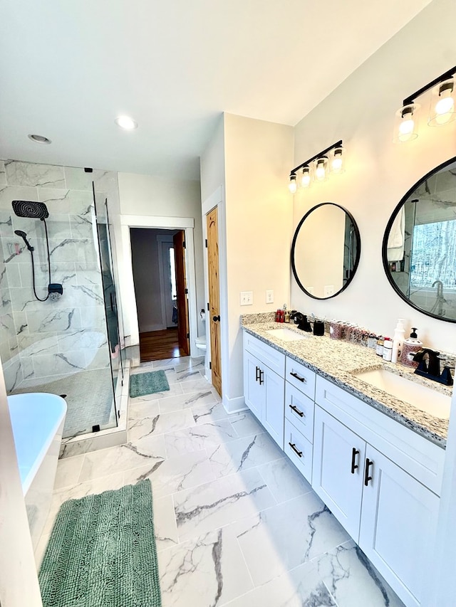 full bathroom featuring a freestanding bath, marble finish floor, a sink, and a marble finish shower