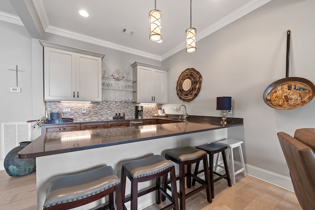 202 Jackson Rd, Milledgeville, GA 31061 - kitchen with dark countertops, crown molding, decorative backsplash, a peninsula, and a breakfast bar area