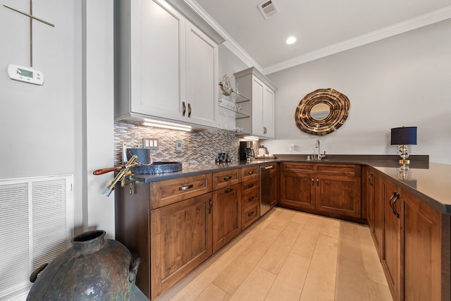 202 Jackson Rd, Milledgeville, GA 31061 - kitchen featuring dark countertops, ornamental molding, tasteful backsplash, stainless steel dishwasher, and light wood-type flooring