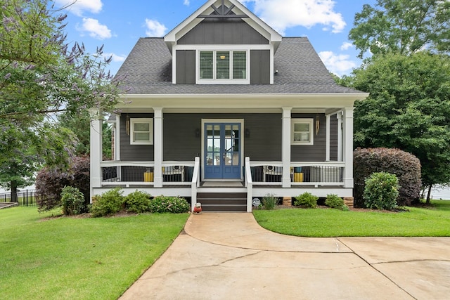202 Jackson Rd, Milledgeville, GA 31061 - view of front of property with a front yard, a porch, a shingled roof, board and batten siding, and french doors