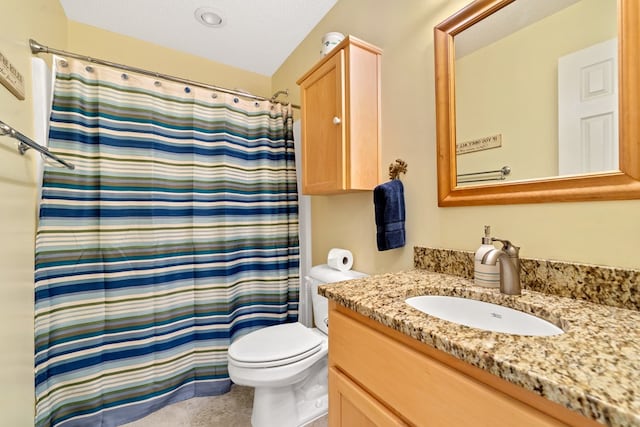 bathroom featuring a textured ceiling, vanity, toilet, and curtained shower