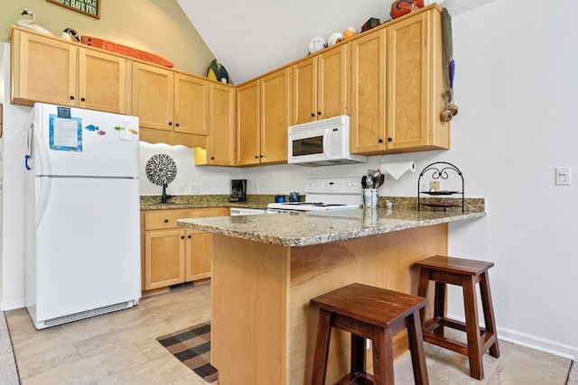 kitchen with light stone counters, kitchen peninsula, vaulted ceiling, white appliances, and light brown cabinetry