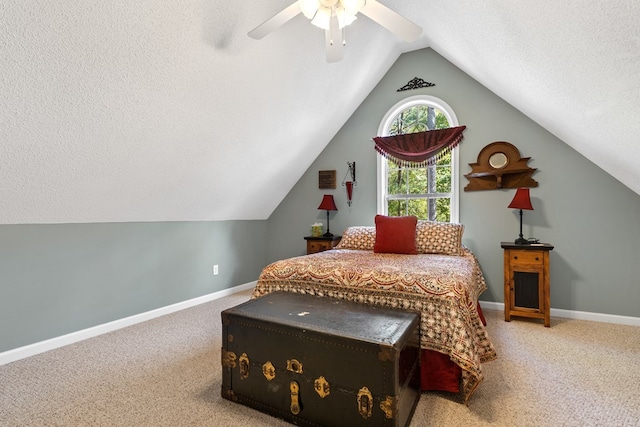 carpeted bedroom with vaulted ceiling, ceiling fan, and a textured ceiling