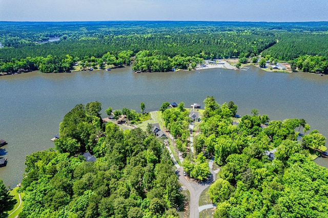 drone / aerial view of a heavily wooded area and a nearby body of water