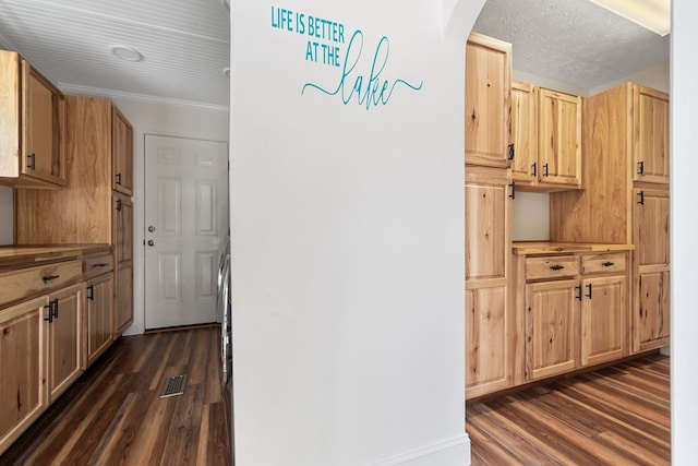 kitchen featuring dark wood finished floors, light brown cabinetry, arched walkways, and light countertops