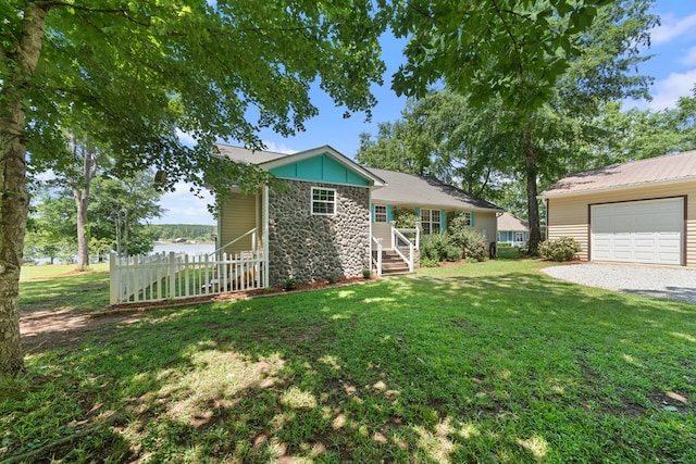 view of front of home with stone siding, board and batten siding, gravel driveway, a detached garage, and a water view