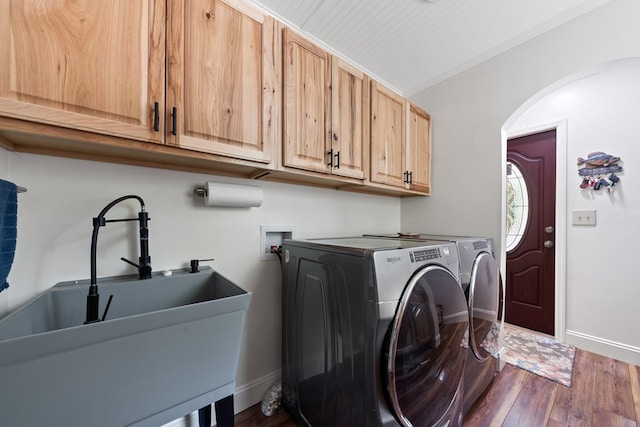 washroom with cabinet space, arched walkways, separate washer and dryer, dark wood-type flooring, and baseboards