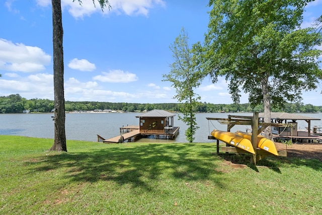 dock area featuring a lawn, boat lift, and a water view