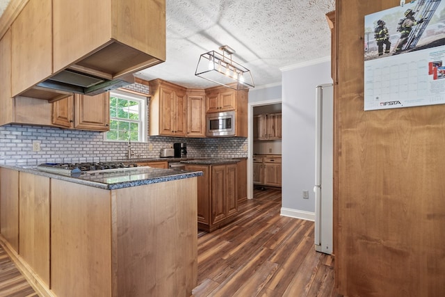 kitchen featuring stainless steel microwave, gas cooktop, ornamental molding, dark wood finished floors, and backsplash