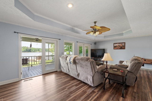 living room with a raised ceiling, a textured ceiling, ceiling fan, dark wood-style flooring, and baseboards