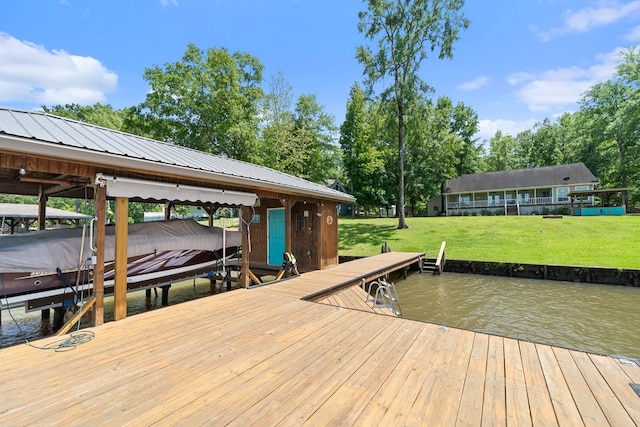 dock featuring boat lift, a water view, and a yard
