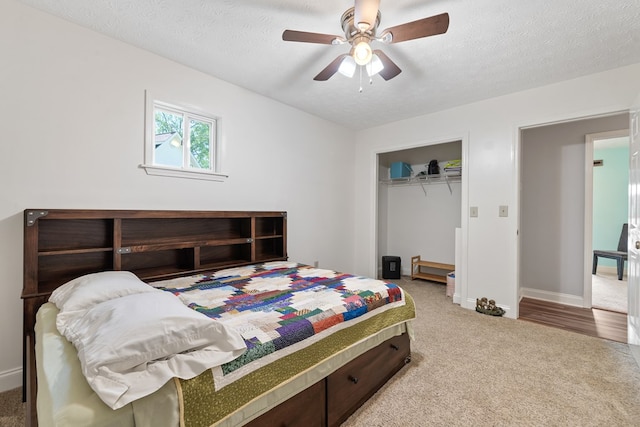 bedroom with carpet floors, baseboards, a closet, ceiling fan, and a textured ceiling