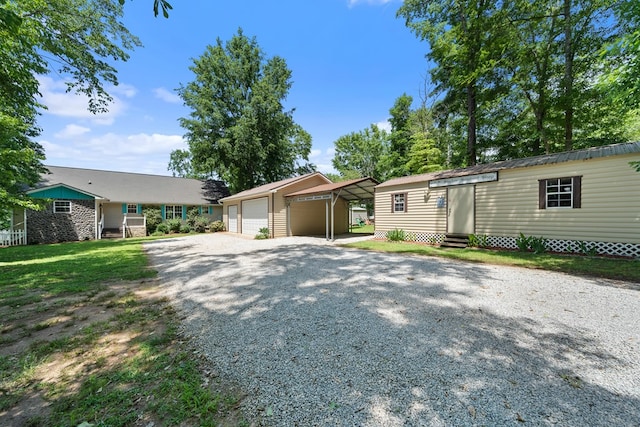 view of front of property featuring entry steps, an outbuilding, a detached garage, and driveway