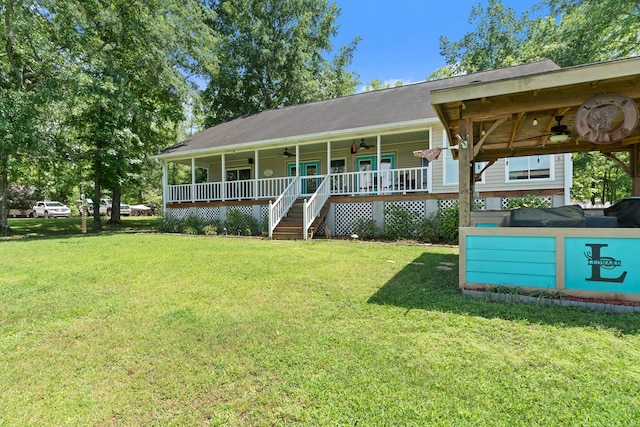 view of front of house with ceiling fan, a front yard, and a porch