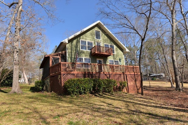 exterior space with a balcony, a wooden deck, and a front yard