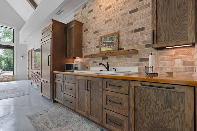 2163 N Jefferson St, Milledgeville, GA 31061 - kitchen featuring light countertops, tasteful backsplash, and high vaulted ceiling