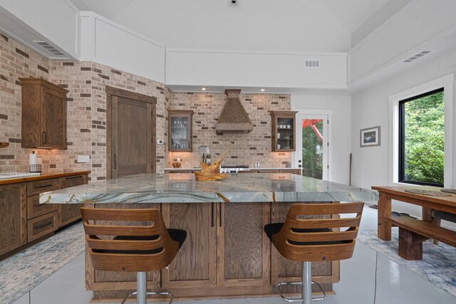 2163 N Jefferson St, Milledgeville, GA 31061 - kitchen featuring glass insert cabinets, tasteful backsplash, dark stone countertops, a kitchen bar, and a high ceiling