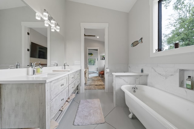 2163 N Jefferson St, Milledgeville, GA 31061 - ensuite bathroom with plenty of natural light, lofted ceiling, double vanity, a freestanding tub, and tile patterned floors