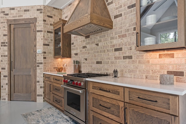 2163 N Jefferson St, Milledgeville, GA 31061 - kitchen featuring premium range, premium range hood, light countertops, glass insert cabinets, and brown cabinets