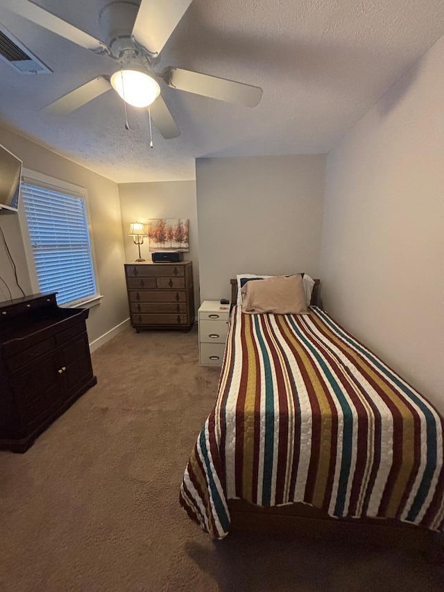 bedroom with light colored carpet, a textured ceiling, a ceiling fan, and baseboards