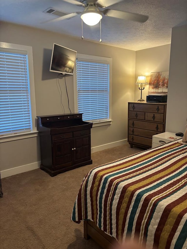 bedroom with carpet, baseboards, a ceiling fan, and a textured ceiling