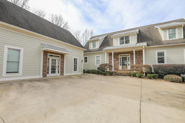 view of front of house with stone siding and a shingled roof