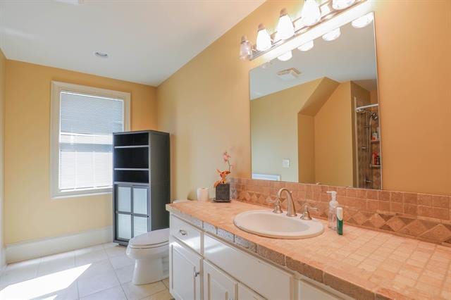 bathroom with tile patterned flooring, toilet, vanity, and walk in shower
