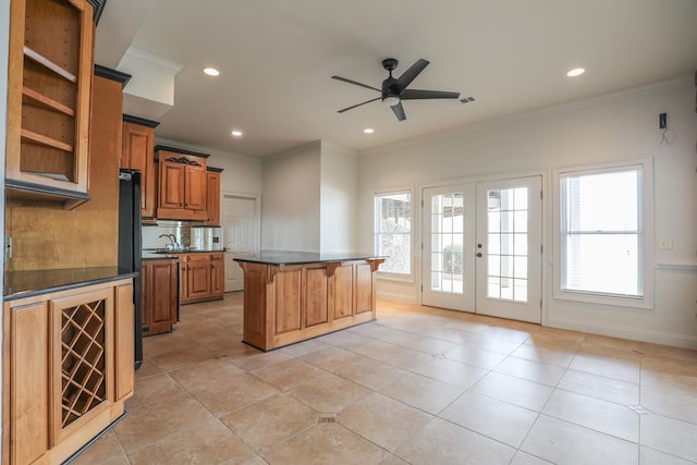 kitchen featuring dark countertops, ornamental molding, brown cabinets, french doors, and a kitchen breakfast bar