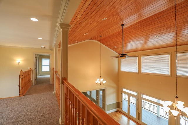 corridor with an upstairs landing, an inviting chandelier, crown molding, wood ceiling, and vaulted ceiling