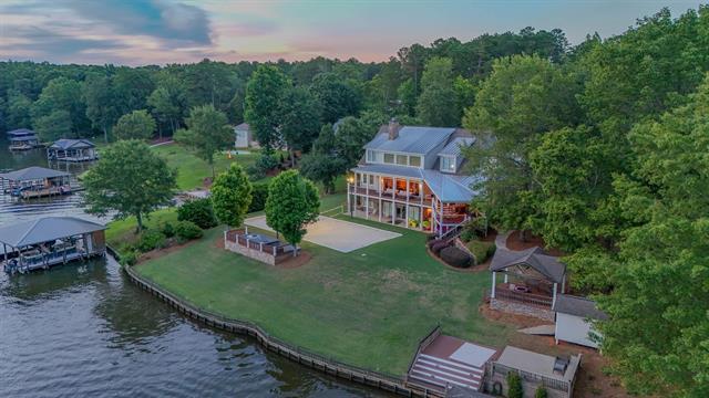aerial view at dusk featuring a view of trees and a water view