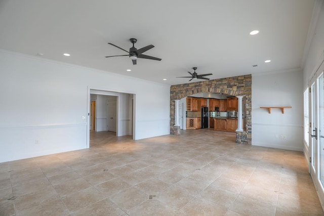 unfurnished living room with ornamental molding, arched walkways, decorative columns, and ceiling fan