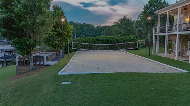 surrounding community with a yard and volleyball court
