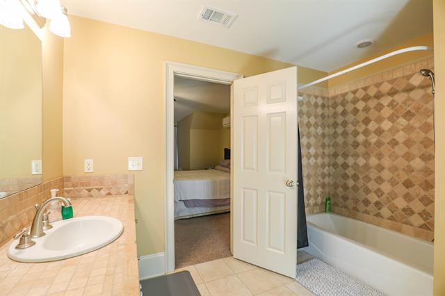 full bath with vanity, visible vents, ensuite bath, tub / shower combination, and tile patterned floors